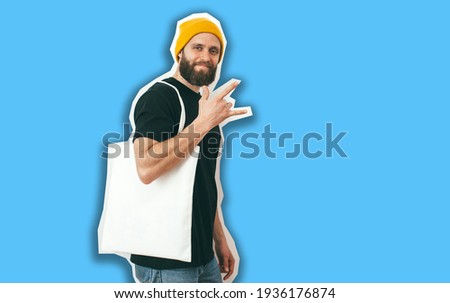 Young man is holding white textile eco bag on color background. Mockup for design