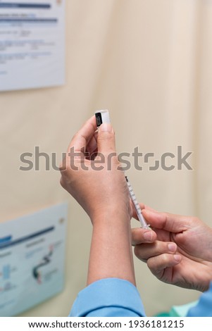 A nurse withdrawing a vaccine from drug ampoule. Selective focus on drug ampoule. Medical concept. 
