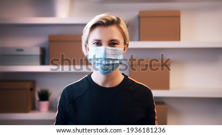 Portrait of young caucasian blond woman with medical mask over her face. High quality photo