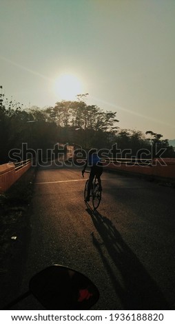 Cycling thorugh the bridge when the sunrise