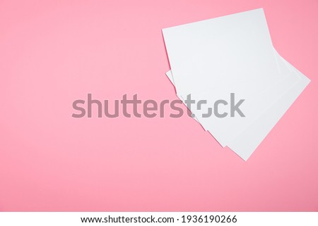 Photo paper without anything. Preparing for photography. Printing photos. Photo paper is on the table. Pink background. White paper.
