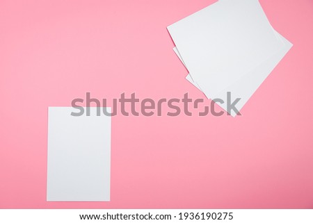 Photo paper without anything. Preparing for photography. Printing photos. Photo paper is on the table. Pink background. White paper. One sheet from the pack lies in the center of the background.