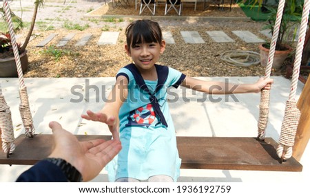 asian little girl Playing the playground swing happy smile