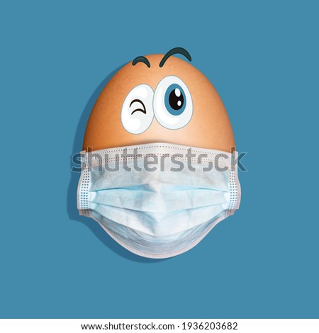 Funny egg with cartooned eyes and face mask isolated on blue background. Easter concept.