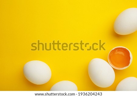 Easter decoration white eggs on yellow background. Top view Royalty-Free Stock Photo #1936204243