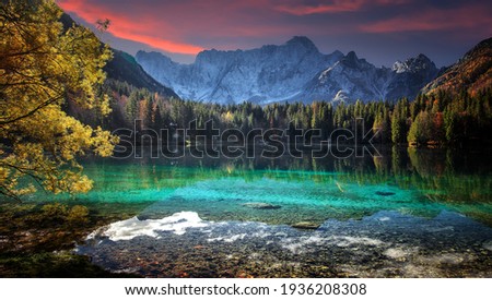 Fantastic Vivid nature landscape. Scenic image of Fusine lake during sunset. Popular travel and hiking destination. Picture of wild area. Awesome nature Background. Concept of an ideal resting place.