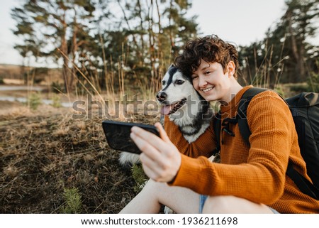 young person taking selfies with her dog 
