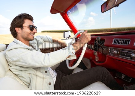 Side view of happy man driving an old car                               