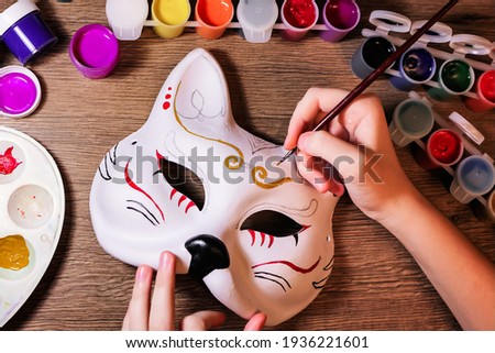 A cat mask design making by teenage girl. Drawing, creativity, hobby, diy, painting, development, education concept. Do it yourself step by step process.