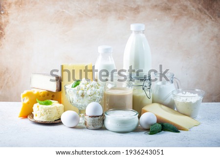 Fresh dairy products, milk, cottage cheese, eggs, yogurt, sour cream and butter on white table Royalty-Free Stock Photo #1936243051