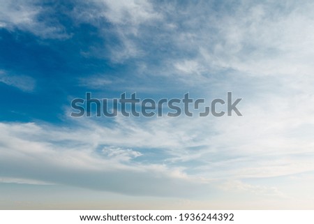 Beautiful blue sky with stretched white clouds.