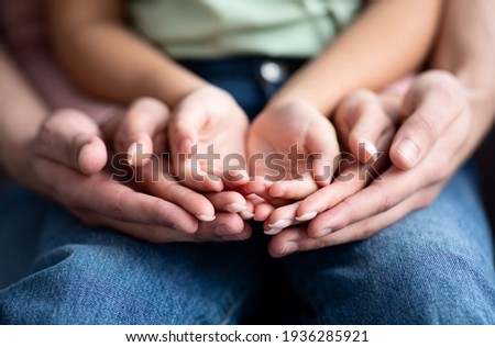 Parents and child placing their hands together, closeup shot Royalty-Free Stock Photo #1936285921