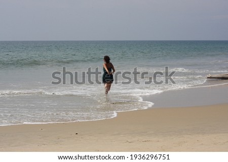 Young woman running to the ocean, sand beach, natural and free
