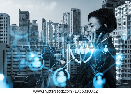 Attractive black businesswoman developer having conference call to protect clients confidential information by inventing solutions. social media icons over Bangkok city background.
