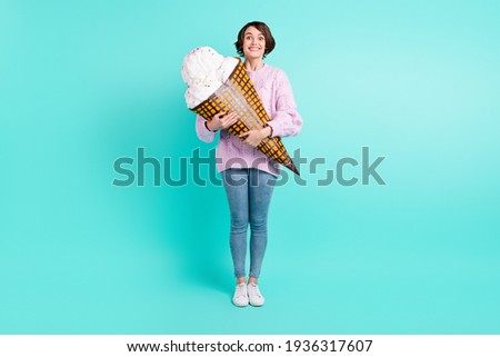 Full length photo of pretty sweet young lady dressed purple pullover holding huge ice-cream isolated teal color background