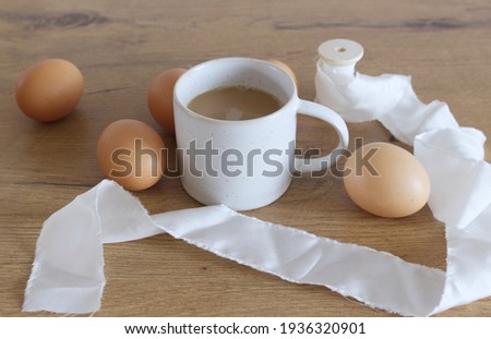 Cozy Easter, spring still life scene. Composition with a mug of coffee and chicken eggs on a wooden table. Vintage feminine-styled photo.                         