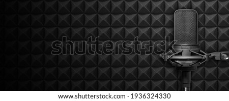 Recording studio microphone with acoustic foam background, music or broadcast banner with copy space Royalty-Free Stock Photo #1936324330