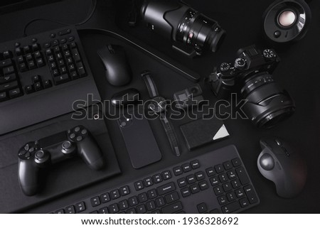 A collection of electronic gadgets all in black organized in a minimalist style. Royalty-Free Stock Photo #1936328692