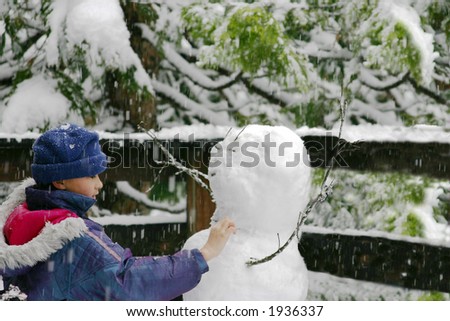 Young girl making of a snowman