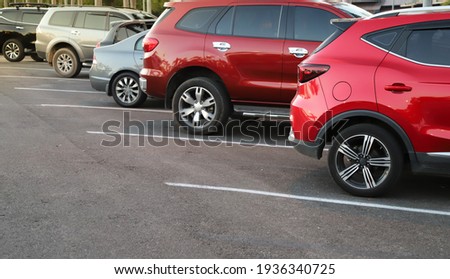 Closeup of rear, back side of red car with  other cars parking in outdoor parking area in bright sunny day. Royalty-Free Stock Photo #1936340725