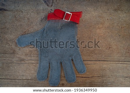 metal protective glove  on wooden table,for butchers or woodworking .