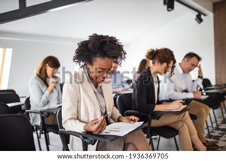 Smiling african american woman taking a test on a business seminar.