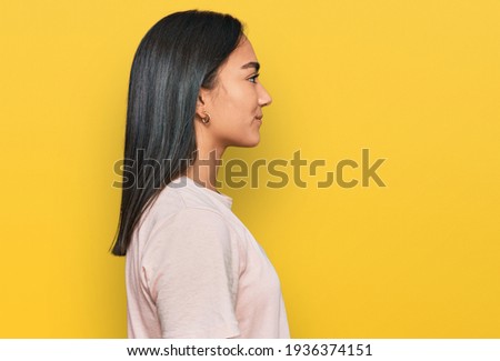 Young asian woman wearing casual clothes looking to side, relax profile pose with natural face with confident smile. 