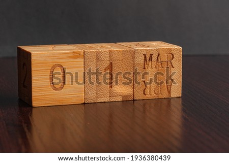 March 01. Image of the calendar March 01wooden cubes  on a brown wooden table reflection and black background. with empty space for text