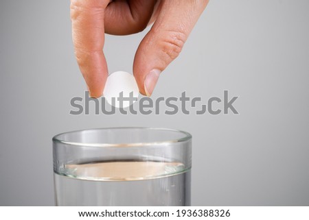 aspirin tablet in glass of water.