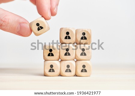 Teambuilding and teamwork concept on wooden cubes with abstract personas employee. Royalty-Free Stock Photo #1936421977