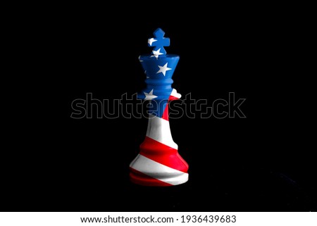 Image of a chess king with american flag defeating white chess pieces. on black background.