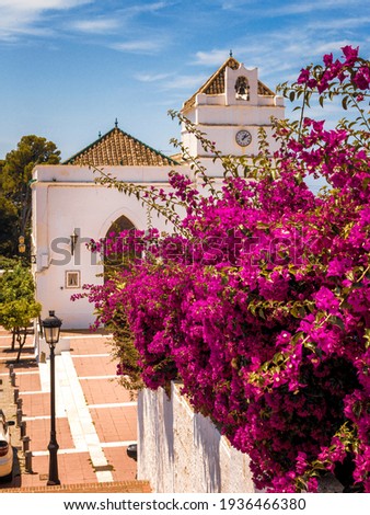 Village Church in  city Maro,, near Nerja, Southern Spain with Bougainvillae in front
