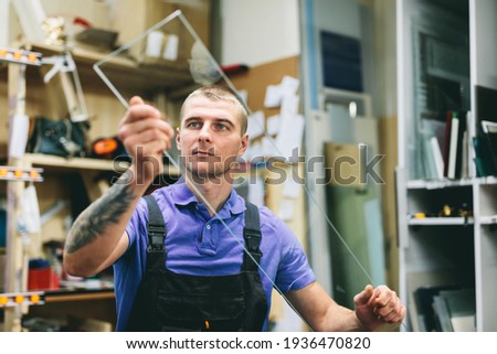 Glazier worker preparing glass in workshop. Industry and manufactory production Royalty-Free Stock Photo #1936470820