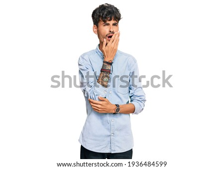 Young hispanic man wearing casual clothes bored yawning tired covering mouth with hand. restless and sleepiness. 