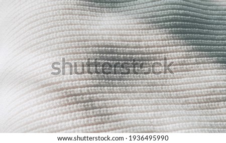 close up view of white sweater texture with sunlight