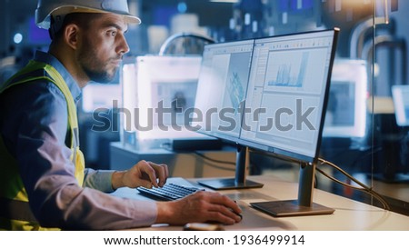 Electronics Design Factory Office: Portrait of Handsome Male Engineer Wearing Safety Vest Working on Computer, Developing Industrial Microchips. Manufacturing Processors. Royalty-Free Stock Photo #1936499914