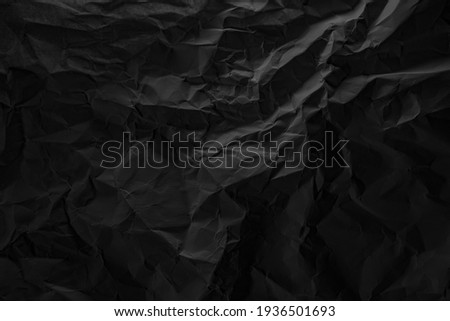 Black crumpled paper texture in low light background Royalty-Free Stock Photo #1936501693