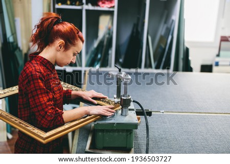 Woman worker sticking together a wooden frame with glue. Industry, manual work