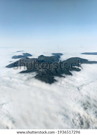 Beautiful photo of mountains in the clouds from above. Photo from top, beautiful landscape, mountain range. Europe, travel, flight. Summer, high cliffs with snow. Wildlife, without people.