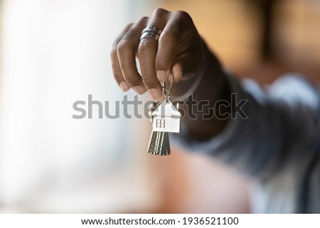 Welcome to new house. Close up of young african american man hand hold bunch of keys. Cropped shot of black guy real estate agent realtor give offer you client key from home flat apartment. Copy space Royalty-Free Stock Photo #1936521100
