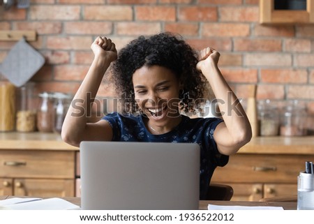 Excellent news. Joyful young mixed race lady read perfect news on pc celebrate passing exam becoming student of prestigious college university. Excited black woman achieve success in online job search