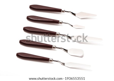 Five art palette knives lie on a white background.Stainless steel painting palette knife isolated on white background.