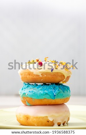 Donut tower stacked pile colouful donut glazed Donat or Donut or Doughnut raditional Freshly Baked  on Table. Sweet Unhealthy Breakfast, Yummy Junkfood. Morning Food, Pile of Fried Sugar