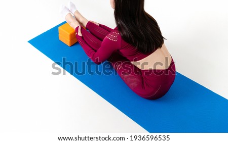 Unrecognizable caucasian woman doing exercises with blocks on white background