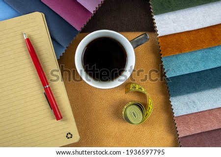 designer's working area for choosing fabrics for upholstered furniture and decor using catalogs