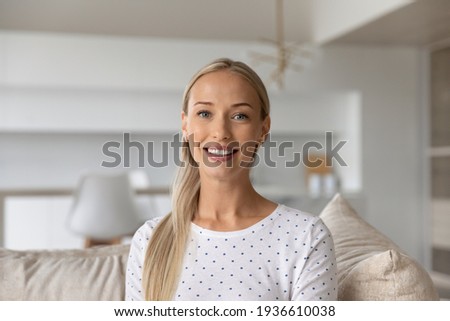Headshot portrait of smiling young Caucasian woman look at camera talk on video call on gadget. Profile picture screen view of happy female have webcam digital conversation. Virtual event concept.