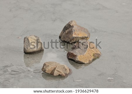An abstract photo of rocks laying on melting ice in Hauser, Idaho.