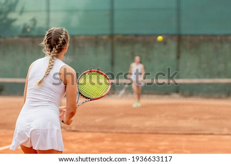 Professional tennis player playing tennis on a clay tennis court on a sunny day Royalty-Free Stock Photo #1936633117