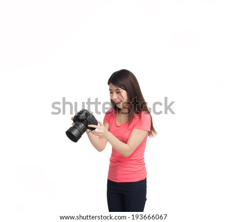 Beautiful young asian girl happy reviewing pictures on camera screen, isolated on white.