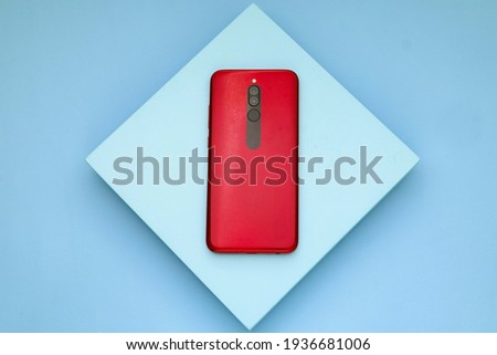 Red smartphone on the blue board, Blue table